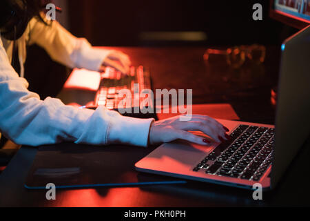 Femme travaillant au bureau à domicile part sur clavier close up. En utilisant les deux ordinateur personnel et l'ordinateur portable Banque D'Images