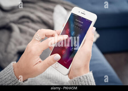 Kiev, Ukraine - le 24 janvier 2018 : Woman holding a brand new Apple iPhone 8 plus et entrez le code d'accès.Le téléphone cellulaire est produit par Apple Computer, I Banque D'Images