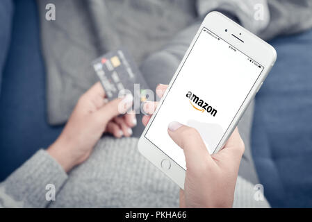 Kiev, Ukraine - le 24 janvier 2018 : Woman holding Apple Iphone 8 plus avec Amazon de chargement mobile app à la maison libre. Banque D'Images