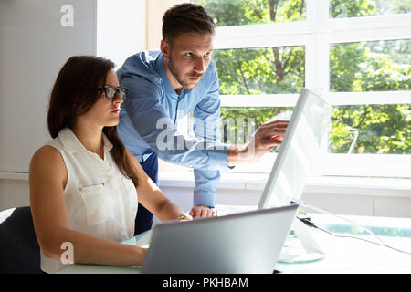 Businessman Businesswoman Pointing at Computer Screen Banque D'Images