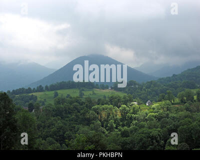 Pyrennean paysage de montagne - briser la lumière du soleil qui brille sur homestead meadows - parmi les nuages bas au-dessus les collines en Ariège Pyrénées, France Banque D'Images