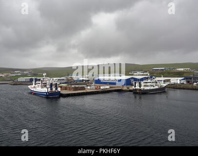 Les bateaux de pêche sont amarrés le Shetland prendre du poisson usine quai sur une journée pluvieuse d'août humide dans les îles Shetland. Lerwick, Ecosse, Royaume-Uni. Banque D'Images