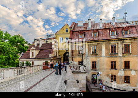 Lublin, Pologne, le 7 juillet 2018. Les touristes qui visitent la vieille ville de Lublin traversant le Grodzka Gate. Les bâtiments anciens sont en attente de rénovation. Banque D'Images