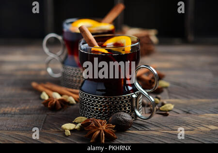 Vin chaud avec des oranges et des épices sur la vieille table en bois. Banque D'Images