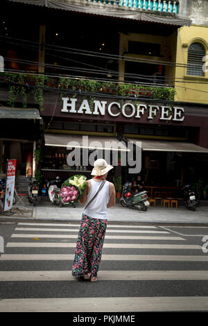 Femme avec bouquet de lotus sur les mains le matin dans vieux quartier de Hanoi, Vietnam. Banque D'Images