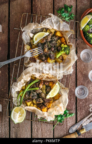 Kleftiko grec traditionnel, un ragoût d'agneau au four avec des pommes de terre, huile d'olive, l'oignon, la carotte, l'ail et fines herbes, servi avec du citron et de l'ouzo. Banque D'Images