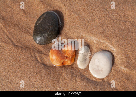 Bon pierre mouillée dans le sable sur la côte d'Antrim à Whitepark Bay, l'Irlande du Nord Banque D'Images