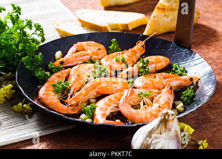 Les crevettes à la poêle dans une casserole en acier avec des herbes. Banque D'Images