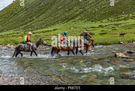 Les randonneurs monter à cheval à travers la rivière Tup, Keskenkyia Jyrgalan, trek en boucle, le Kirghizistan Banque D'Images