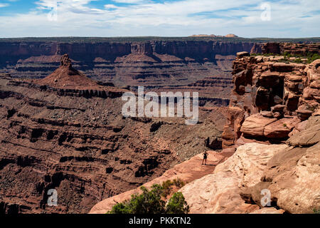 Une femme se tient près de la pointe de Dead Horse Point vers les Montagnes La Sal, Dead Horse Point State Park, Utah, USA. Banque D'Images