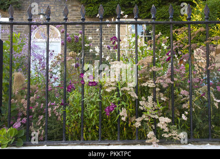 Maison géorgienne dans la colline de Downshire, Hampstead, avec jardin plein de plantes, qui poussent à travers les grilles, London NW3, England, UK Banque D'Images