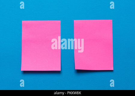 Deux notes rose vide, un autocollant sur un fond bleu pour l'écriture des idées et tâches Banque D'Images