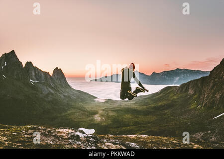 Happy man jumping outdoor adventure concept de vie Voyage Vacances actives en Norvège montagnes coucher de succès et émotions euphorie fun Banque D'Images