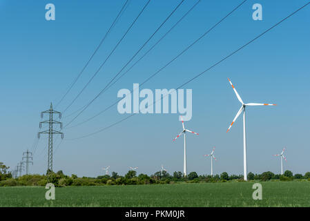 Les lignes électriques et centrales éoliennes sous un ciel bleu en Allemagne Banque D'Images