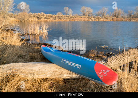 Fort Collins, CO, USA - Le 19 mars 2018 : Courses de stand up paddleboard sur une rive du lac - 2018 modèle de tous les Star SUP par tribord. Banque D'Images