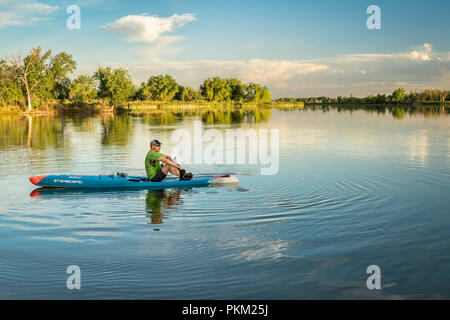 Fort Collins, CO, USA - 22 juin 2018 : un pagayeur reposant sur une course stand up paddleboard par tribord du soir Cours d'entraînement. Banque D'Images