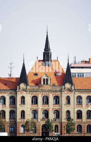 Bâtiment historique orné au bord de la rivière avec toit en tuiles rouges et trois flèches sombres à Bratislava, Slovaquie Banque D'Images