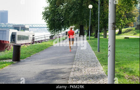 Joggeur féminin courant le long de la promenade du Danube à Bratislava, Slovaquie Banque D'Images