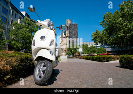 Scooter en stationnement au centre-ville de Berlin. Dans l'arrière-plan est la Breitscheidplatz avec l'Eglise du Souvenir. Banque D'Images