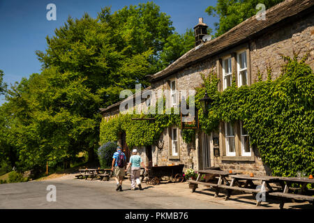 UK, Yorkshire, Wharfedale, Appletreewick, promeneurs passant Craven Arms public house Banque D'Images