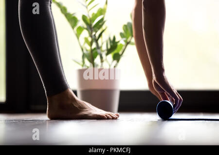 Femme en déroulant un tapis de yoga, vue en gros Banque D'Images