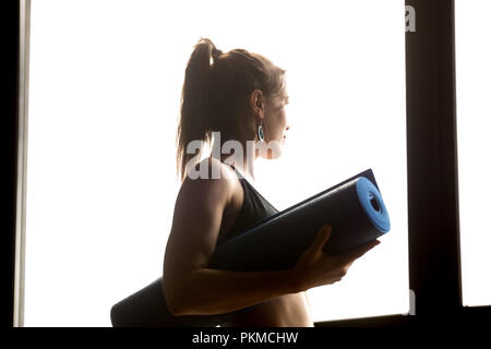 Sporty woman holding blue tapis de yoga, concept de vie sain Banque D'Images