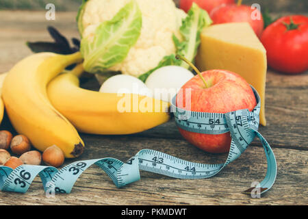 Les fruits et légumes, ruban à mesurer sur le vieux fond de bois. Concept de la nutrition appropriée. La tonalité de l'image. Banque D'Images