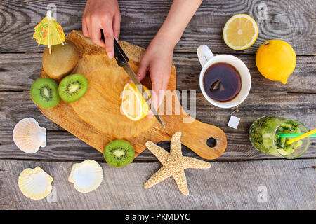 Femme prépare le thé avec du citron. Vue d'en haut. Banque D'Images