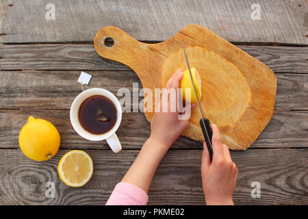 Femme prépare le thé avec du citron. Vue d'en haut. Banque D'Images