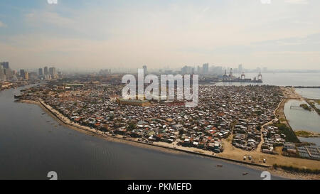 Vue aérienne du quartier défavorisé de bidonvilles de Manille, des ghettos, de vieilles maisons en bois, cabanes. Bidonville de Manille, aux Philippines. Banlieue de Manille, vue depuis l'avion. Banque D'Images