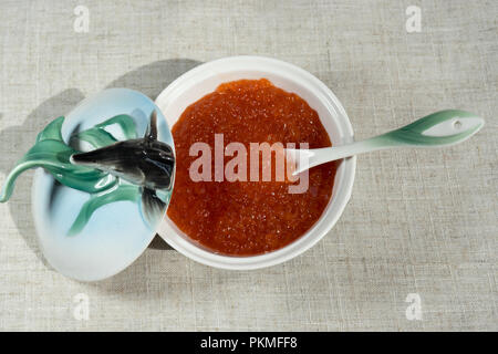 Grand caviar rouge dans une belle icône de porcelaine sur une nappe gris. L'alimentation, de délicatesse Banque D'Images