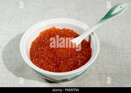 Grand caviar rouge dans une belle icône de porcelaine sur une nappe gris. L'alimentation, de délicatesse Banque D'Images