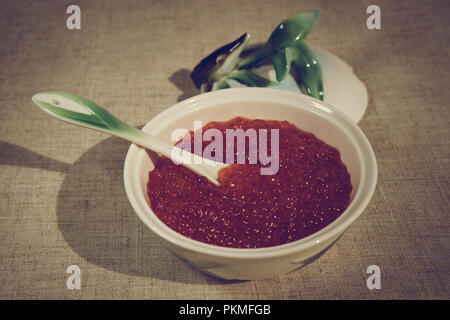 Grand caviar rouge dans une belle icône de porcelaine sur une nappe gris. L'alimentation, de délicatesse Banque D'Images