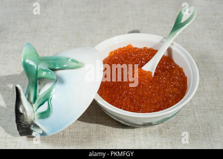 Grand caviar rouge dans une belle icône de porcelaine sur une nappe gris. L'alimentation, de délicatesse Banque D'Images