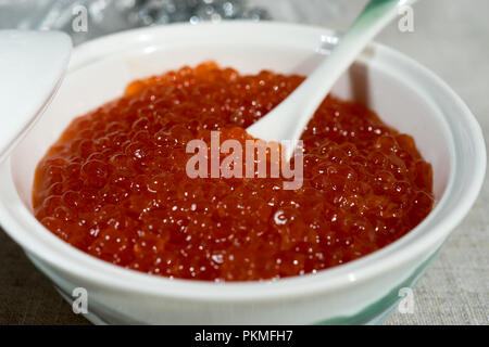 Grand caviar rouge dans une belle icône de porcelaine sur une nappe gris. L'alimentation, de délicatesse Banque D'Images