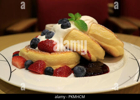 Savoureuses Crêpes soufflé moelleux avec de la crème fouettée et mélanger les petits fruits servis sur plaque blanche Banque D'Images