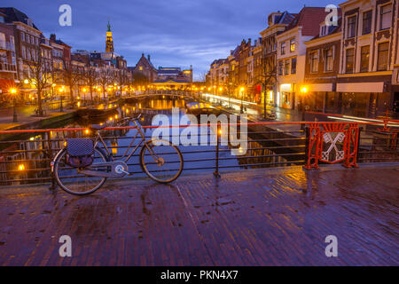 Vue de nuit en centre-ville de Leiden avec canal, pont, bicyclettes. Street Nieuwe Rijn. Vue de l'Hôtel de ville de Leiden. Aux Pays-Bas. Banque D'Images