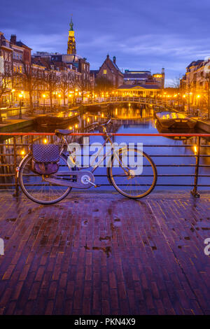 Vue de nuit en centre-ville de Leiden avec canal, pont, bicyclettes. Street Nieuwe Rijn. Vue de l'Hôtel de ville de Leiden. Aux Pays-Bas. Banque D'Images