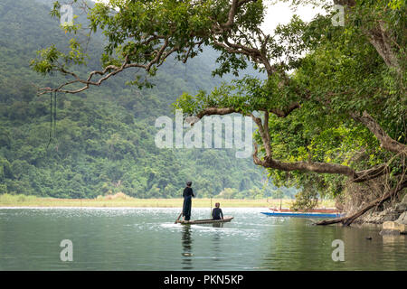 Une femme de la minorité ethnique Tay, dans son costume traditionnel est l'aviron une pirogue sur le lac Ba Be. Banque D'Images