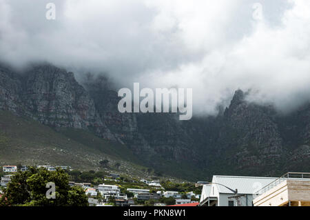 Maisons sur une colline avec la nuée couvrit la montagne de la table derrière eux à Camps Bay, Afrique du Sud Banque D'Images