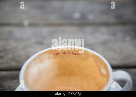 Une tasse de café avec un commerce équitable et de l'organic logo imprimé sur la tasse avec l'exemplaire de l'espace. Banque D'Images