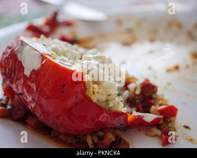 Restes d'un manger paprika rouge rempli de riz sur une plaque après le déjeuner. Banque D'Images