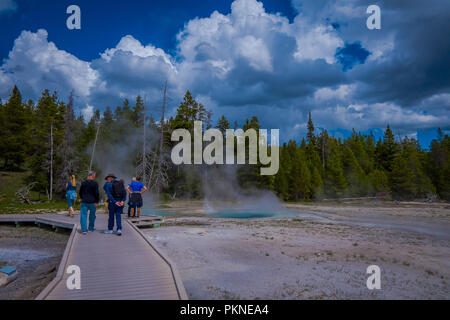 YELLOWSTONE, Montana, USA 24 mai 2018 : les touristes non identifiés dans le Old Faithful Geyser dans le parc national de Yellowstone sur une promenade entourée par les vapeurs Banque D'Images