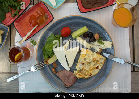 Petit-déjeuner préparé sur la table de bois, fromages, confitures, tomates, concombre, la viande fumée, du beurre, du miel, des olives, des pains Banque D'Images