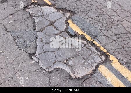 Chaussée endommagée de Yokohl dur en Californie, Etats-Unis - asphalte fissuré blacktop avec poule et correctifs. Banque D'Images