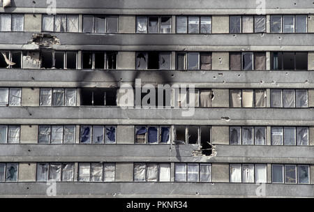 15 mars 1993 pendant le siège de Sarajevo : les étages supérieurs d'un immeuble de bureaux. Shell, d'obus et de balles, les vitres bouchées avec des planches, recouvert de bâches en plastique du HCR et roussi sur où il y a eu un incendie. Banque D'Images