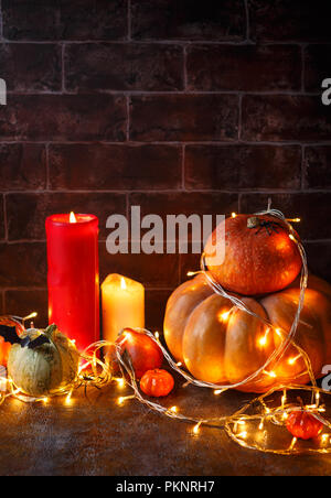 Citrouilles d'automne, des bougies et un brillant garland. Happy Halloween Greeting Banque D'Images