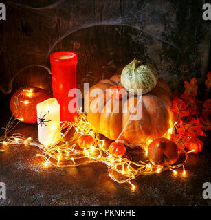 Citrouilles d'automne, des bougies et un brillant garland. Happy Halloween Greeting Banque D'Images