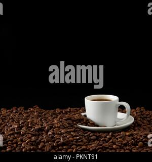 Tasse de café avec des grains de café, studio shot. Banque D'Images