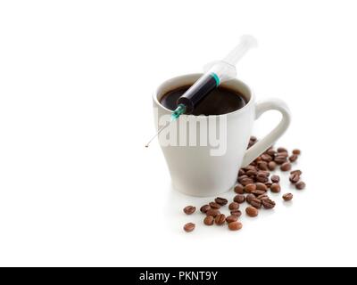 Tasse de café avec des haricots et d'une seringue, studio shot conceptuel. Banque D'Images